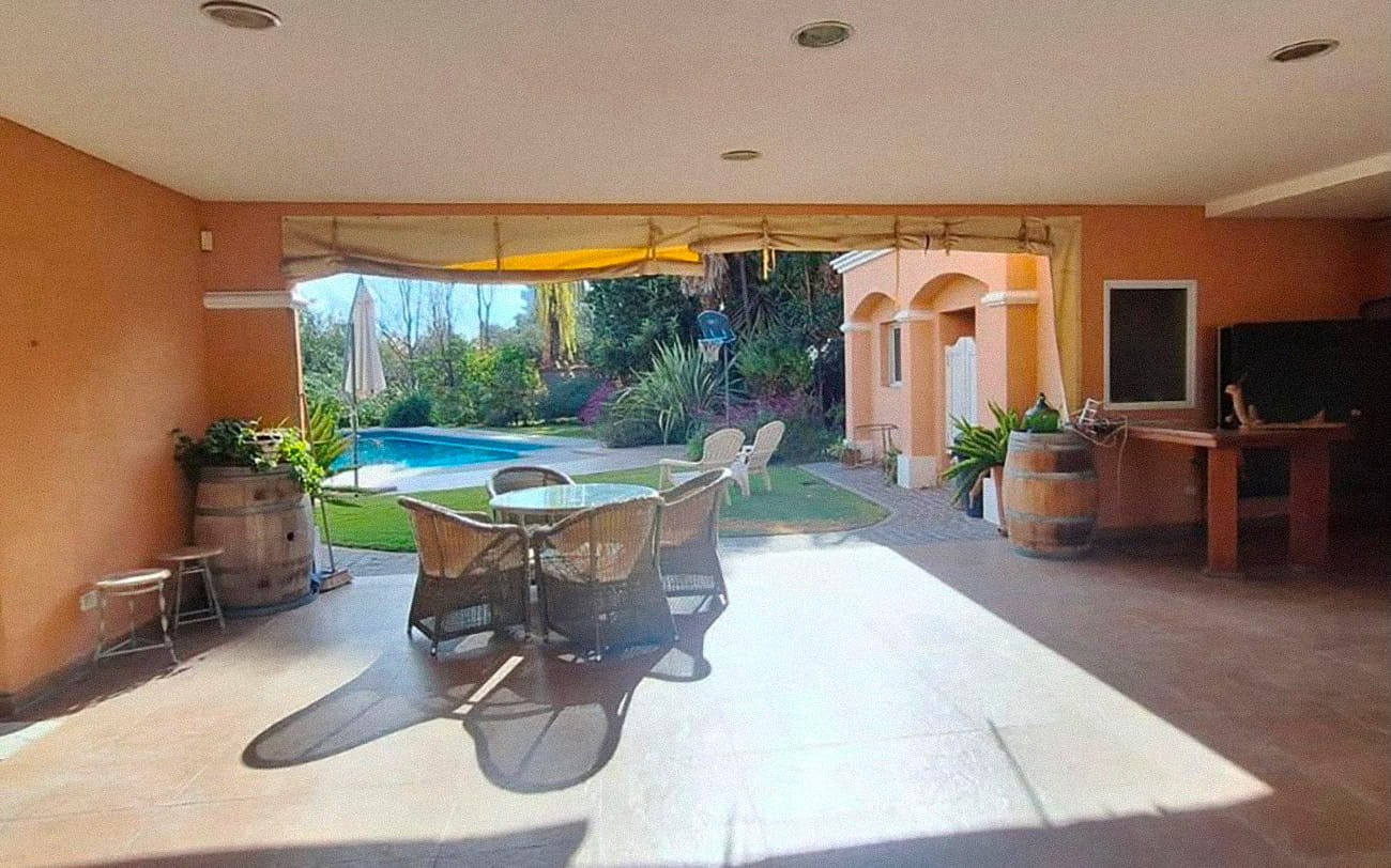 Galería cubierta de la residencia Pewen con vista al jardín y la piscina