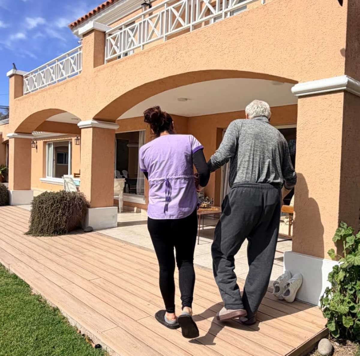 Persona mayor acompañada por una cuidadora en los espacios exteriores de Pewen